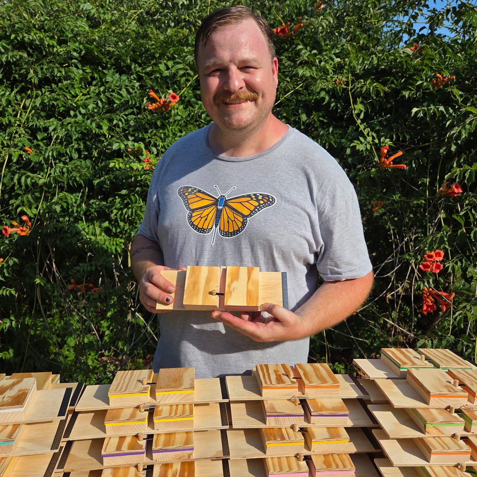Don Crawford holding a handcrafted monarch tagging board