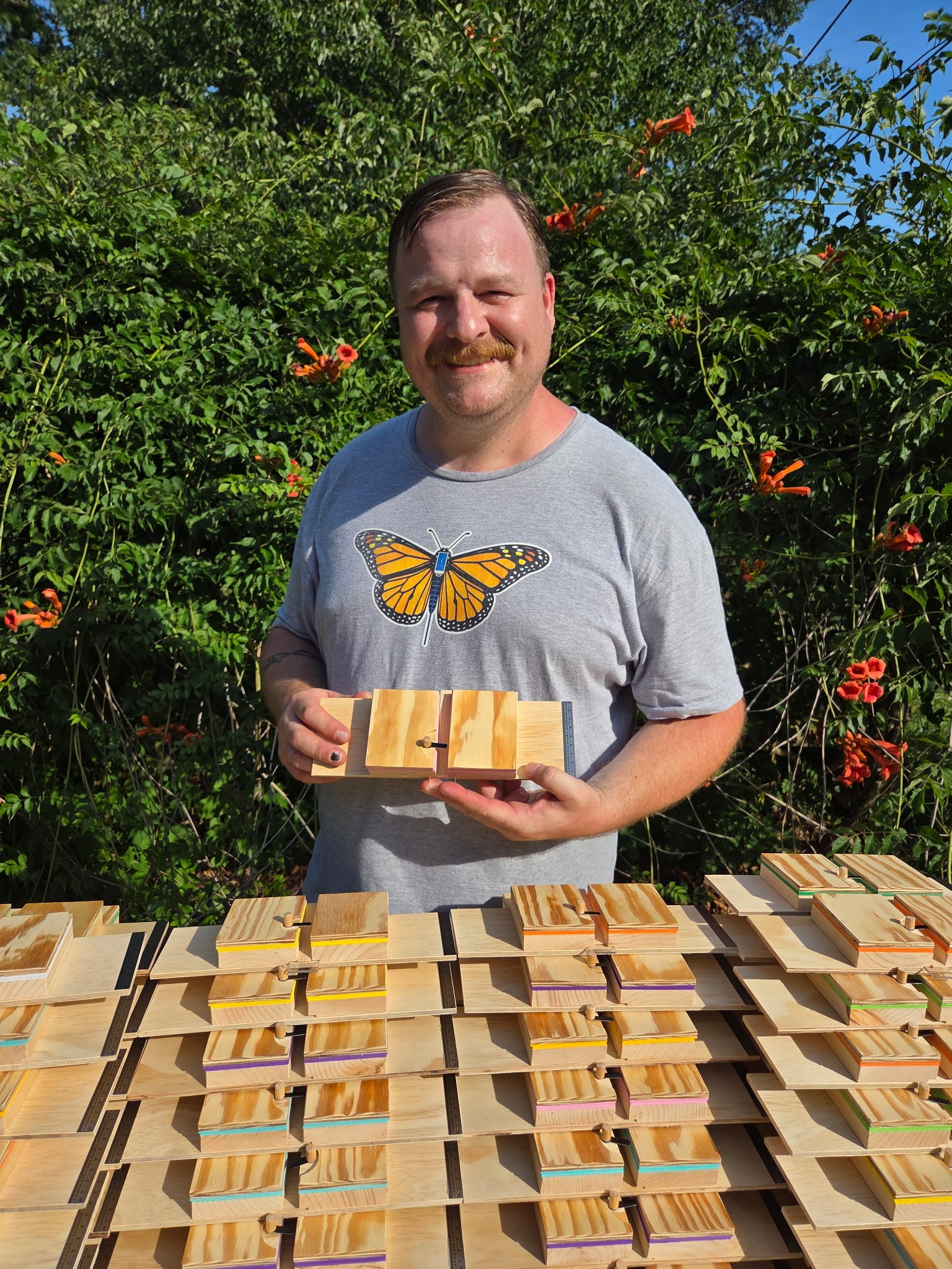 Don Crawford holding a handcrafted monarch tagging board