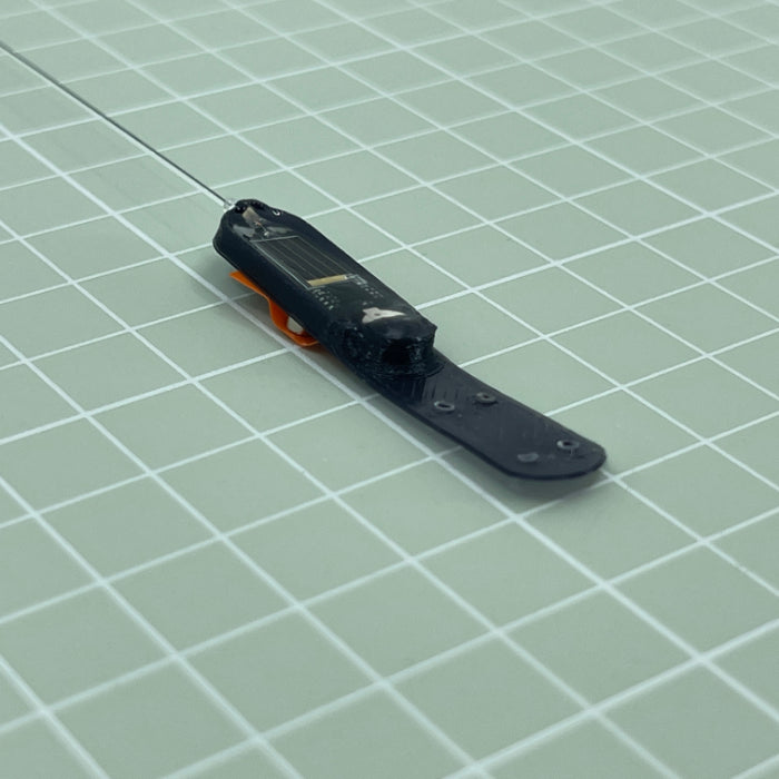 HybridTag mounted in a 3D printed chassis for attaching with a Leg-loop harness. The orange tape is holding the small activation/deactivation magnet in place.